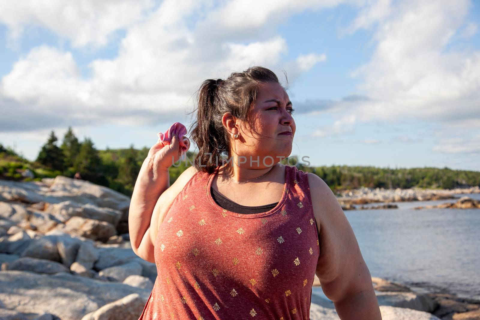 woman is fed up wearing a face mask and throws it into the ocean