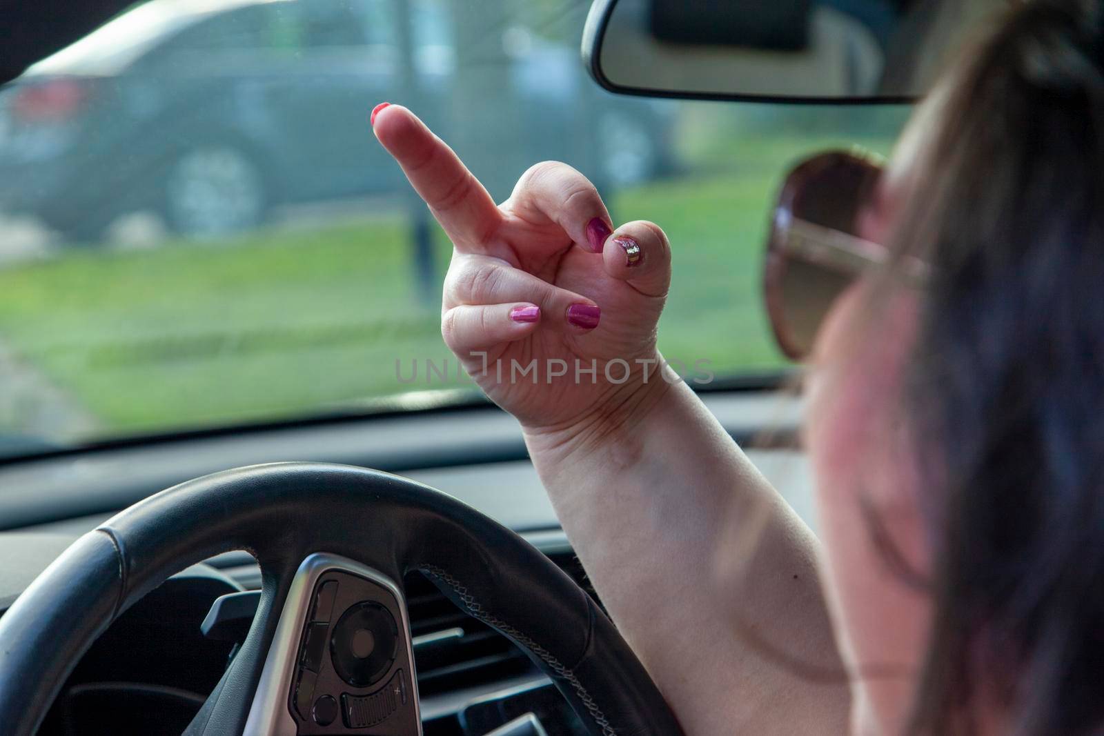 driver with road rage flips someone off while driving in the car