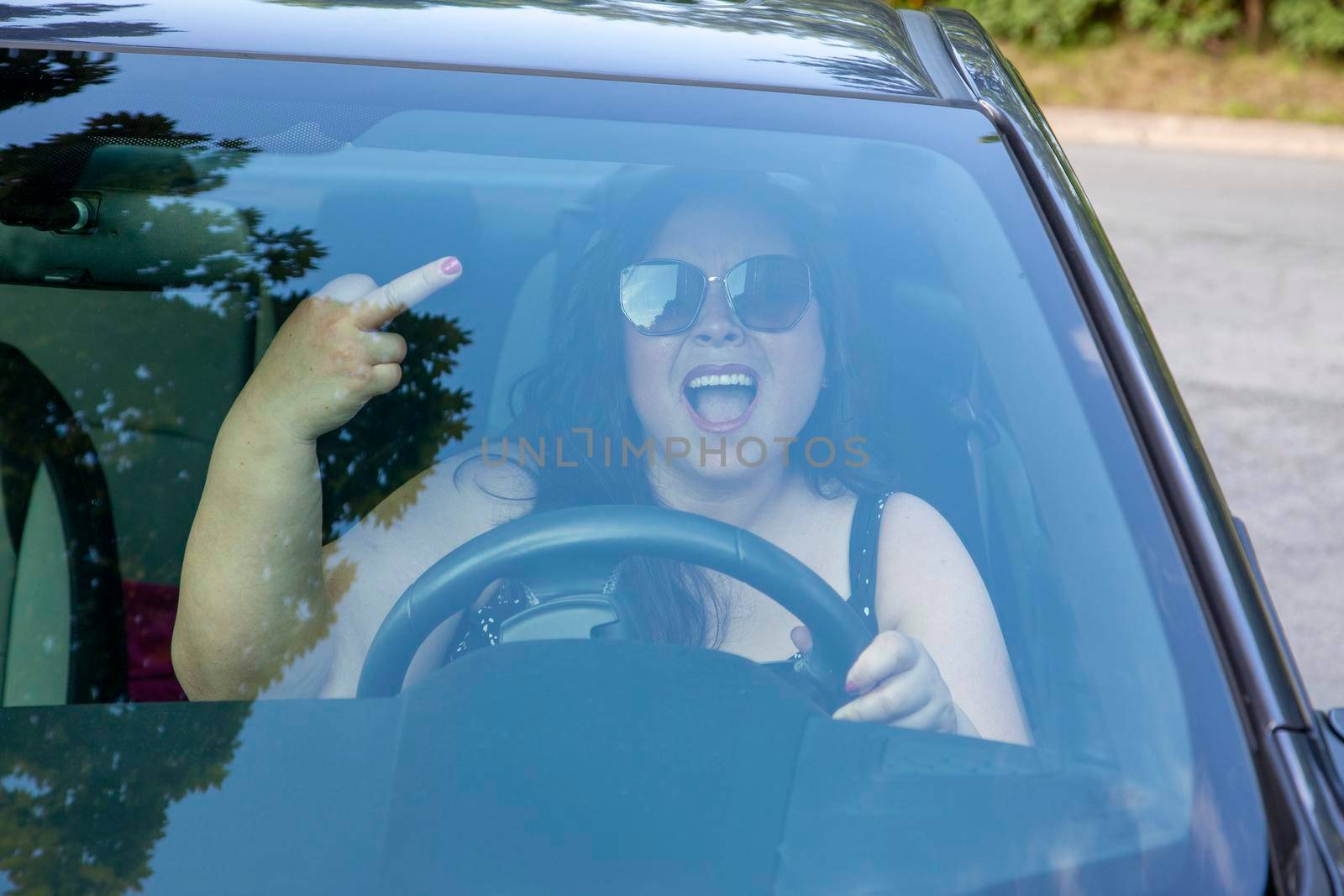 woman is yelling and giving someone the middle finger while driving 