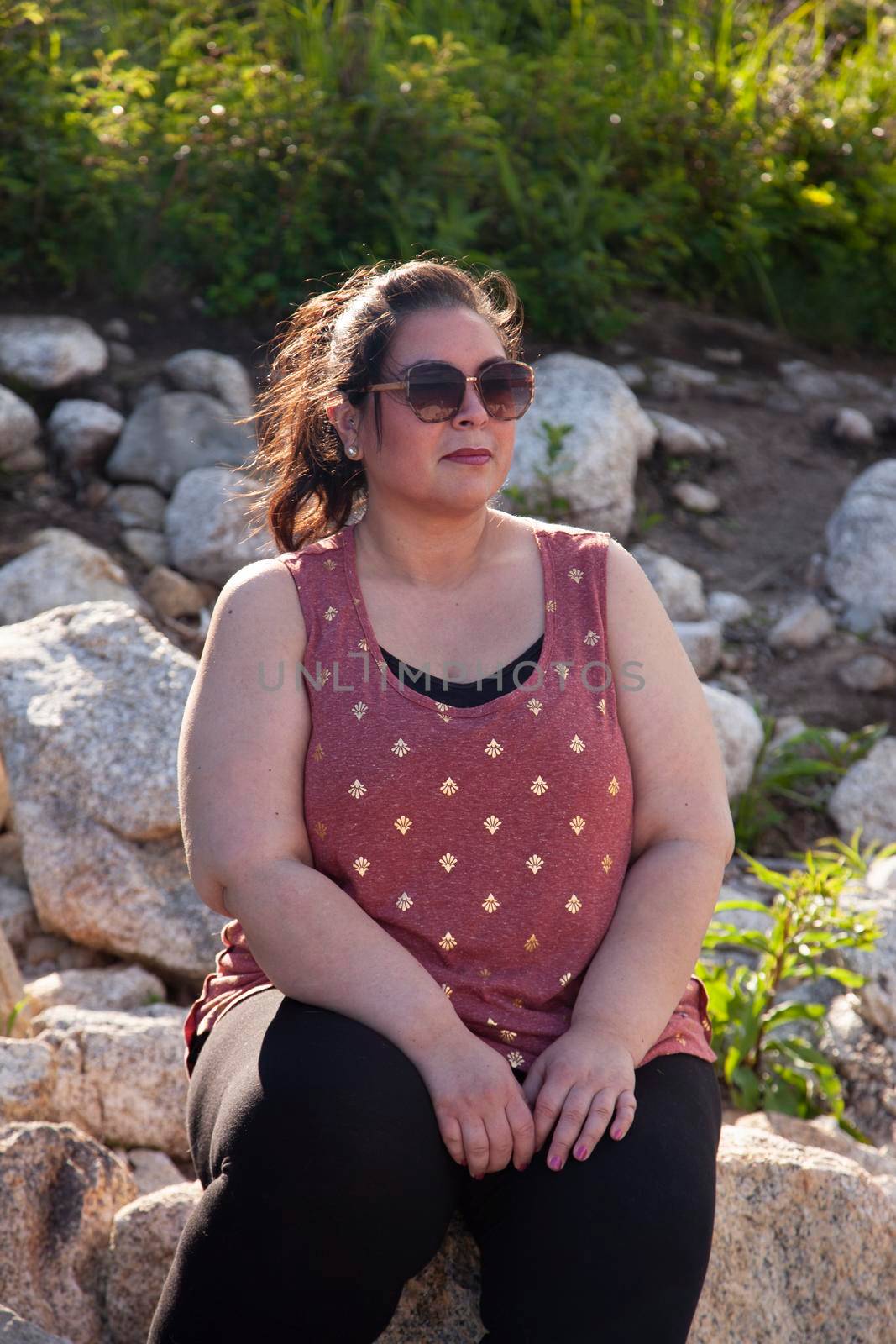 Woman sitting on rocks outside  by rustycanuck