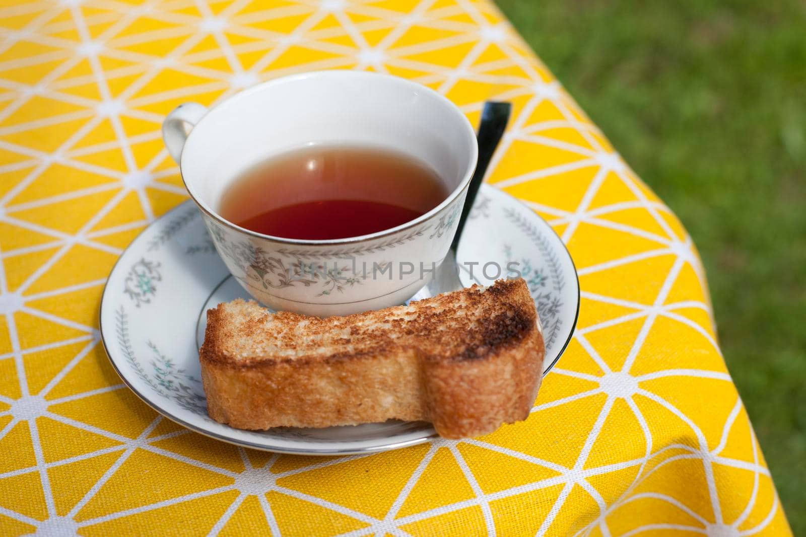 Pretty tea cup and saucer with bread  by rustycanuck