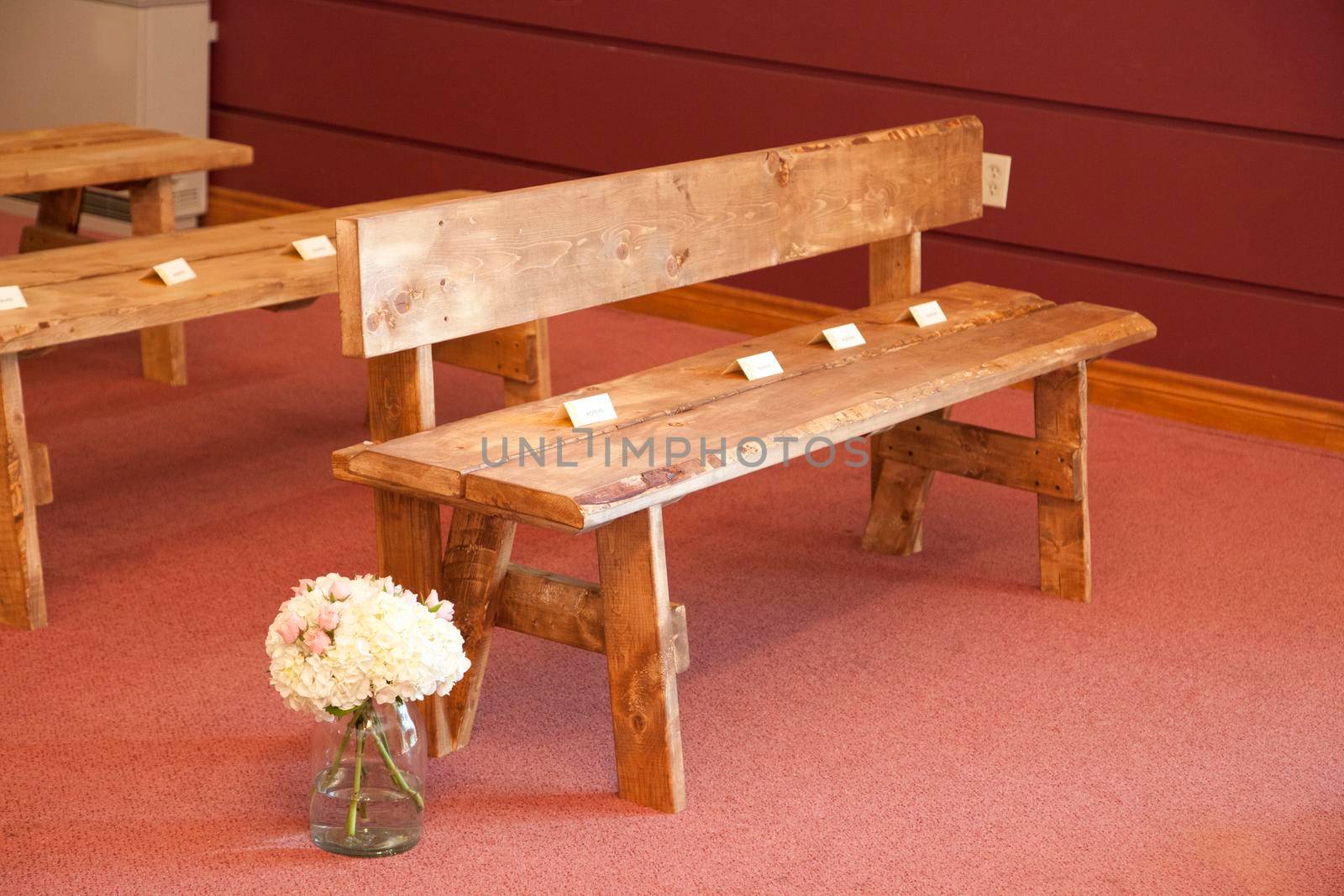 beautiful wooden seats with reserved signs and lovely flowers at a wedding or special event