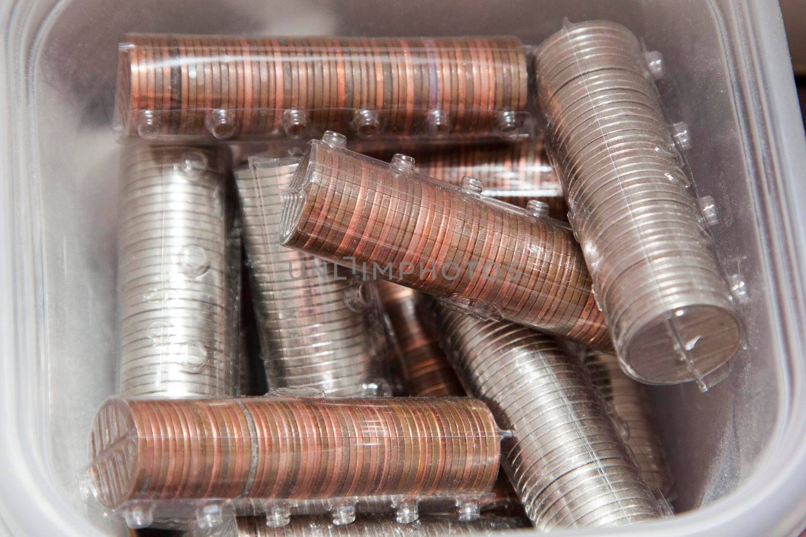 plastic container filled with coins of pennies, nickles and dimes for savings