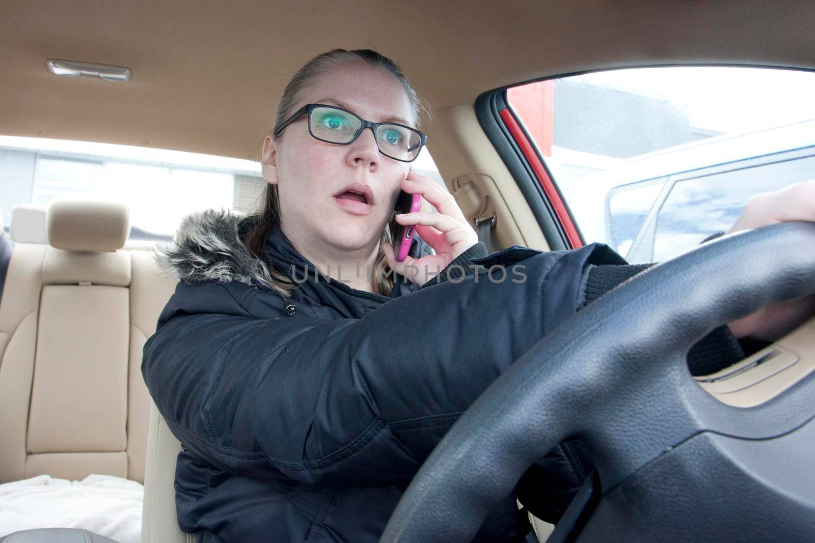  a woman talks on her cell phone while driving the car 