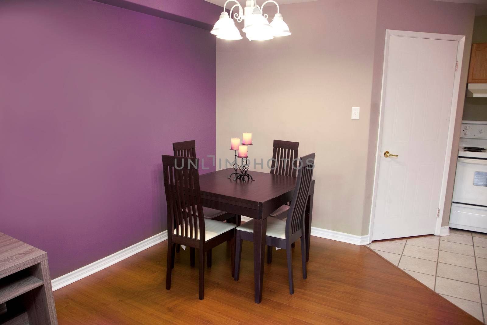 purple walls with a dark wood table and chair set for four in a kitchen or dining area of a home