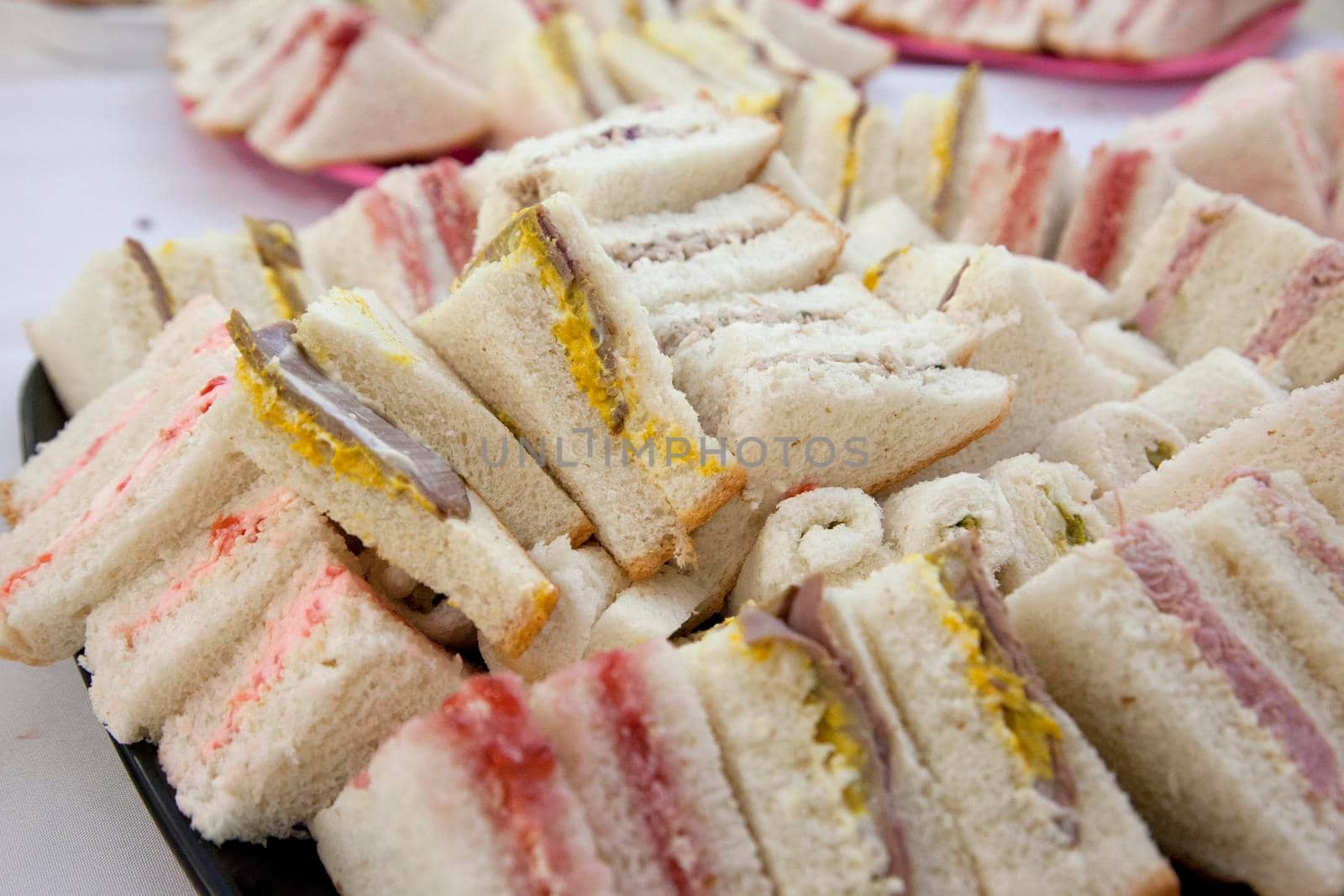 Delicious looking tiny triangle finger sandwiches at a party 