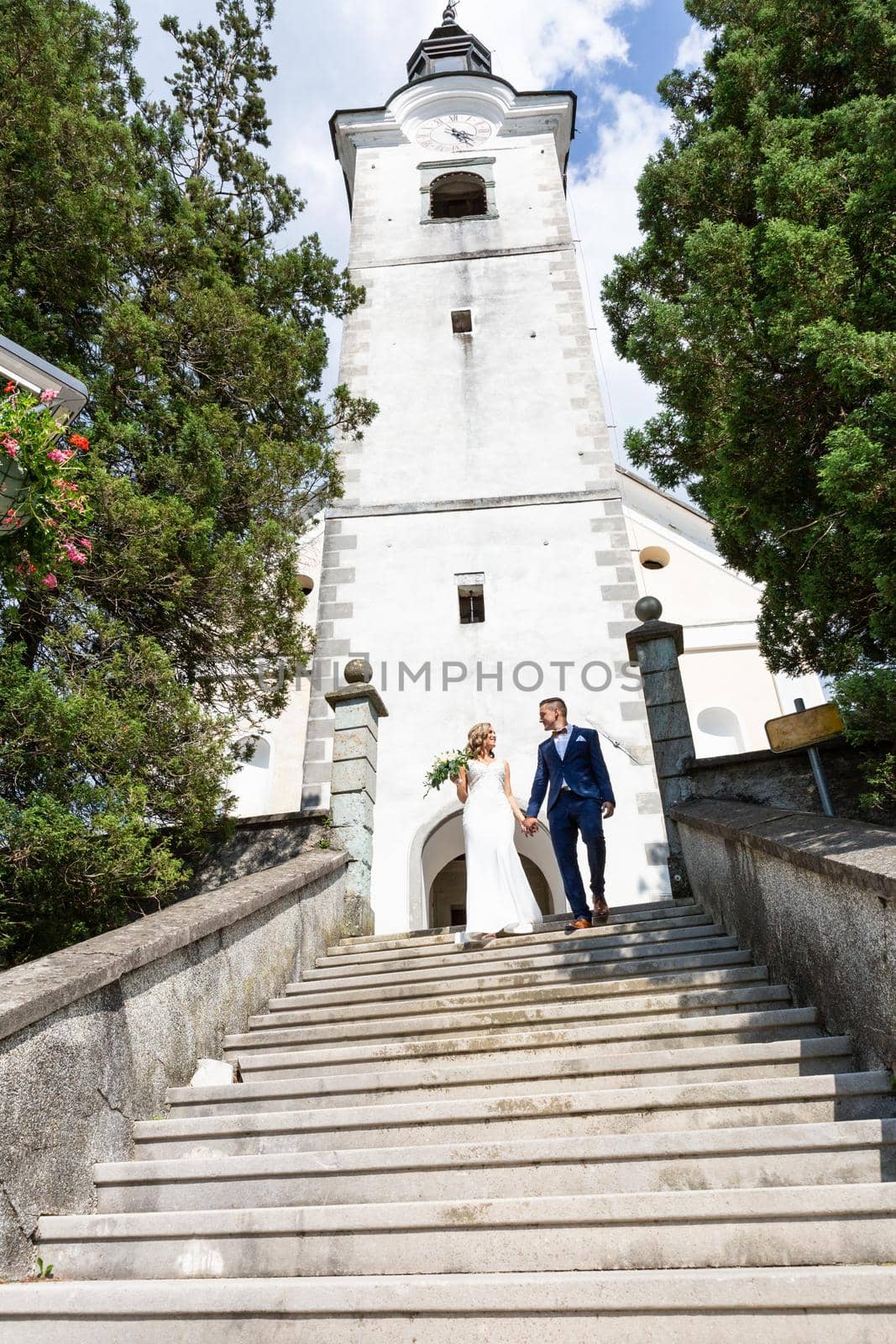 The Kiss. Bride and groom kisses tenderly on a staircase in front of a small local church. by kasto