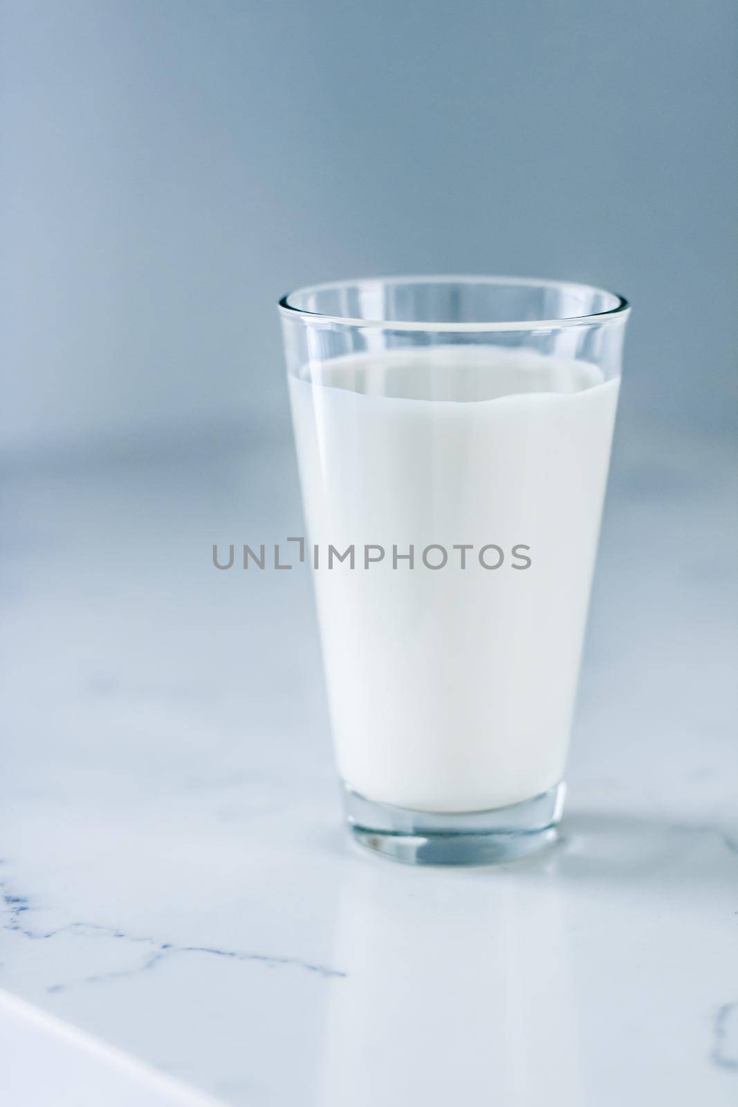 Dairy, healthy nutrition and breakfast concept - World Milk Day, full glass on marble table