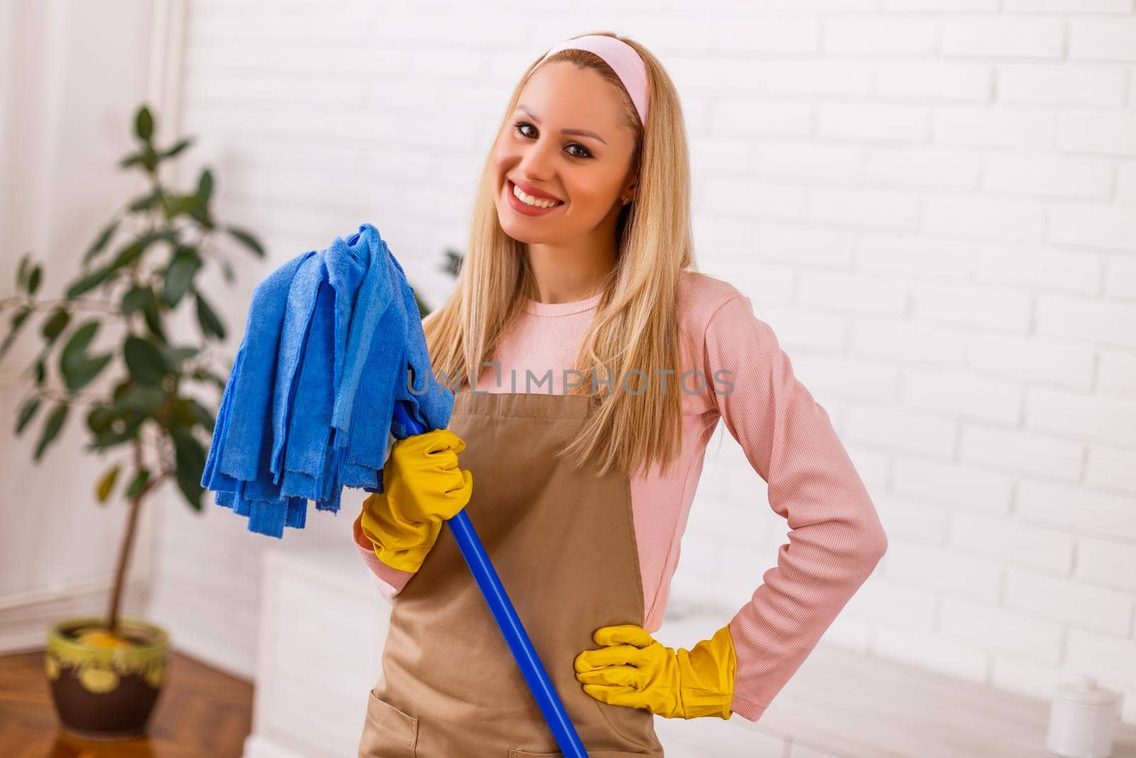 Beautiful housewife enjoys cleaning  her home.