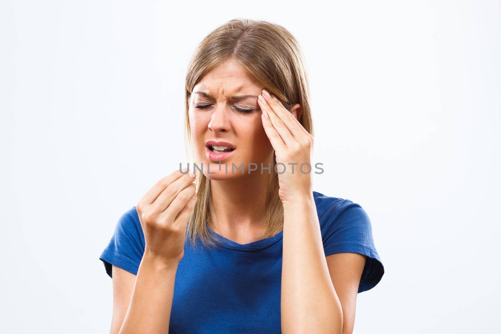 Young woman is having a headache and taking pill