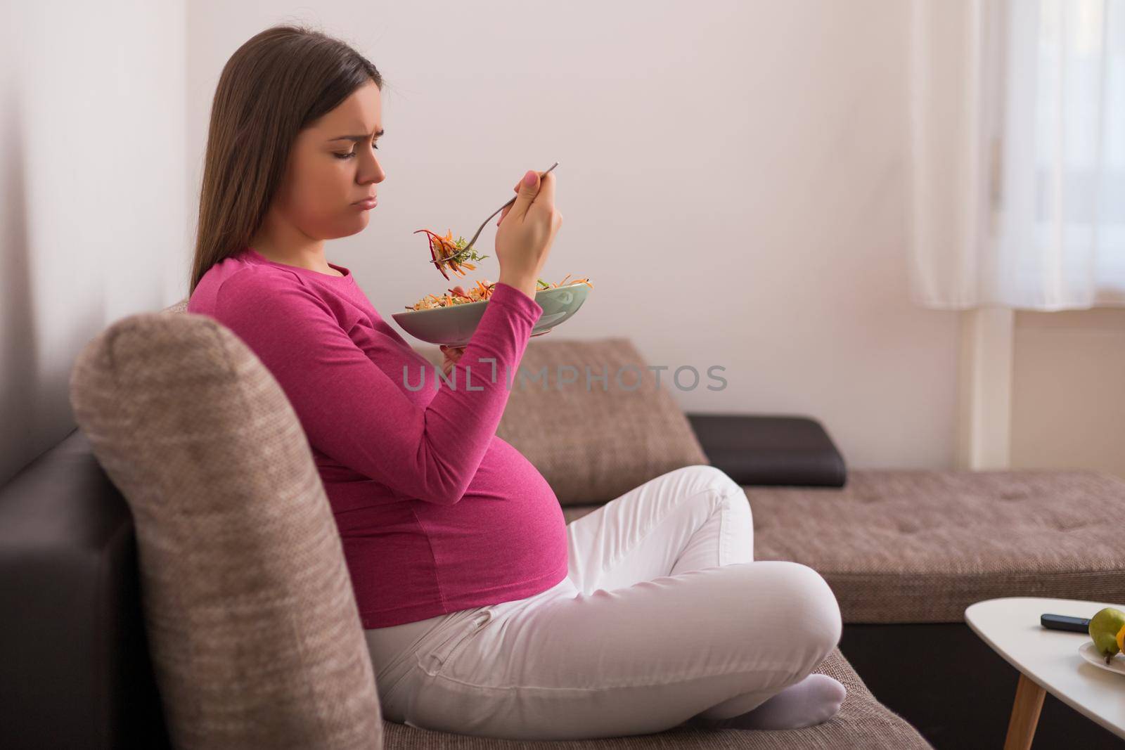 Sad pregnant woman doesn't want to eat vegetables.