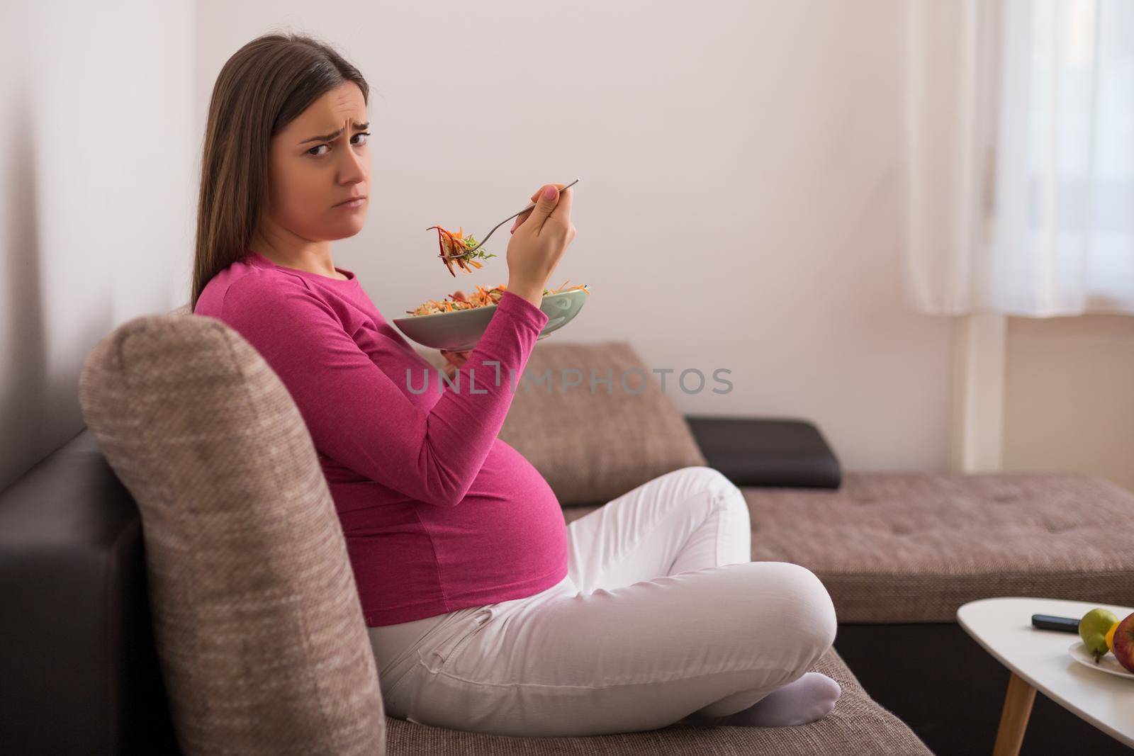 Sad pregnant woman doesn't want to eat vegetables.