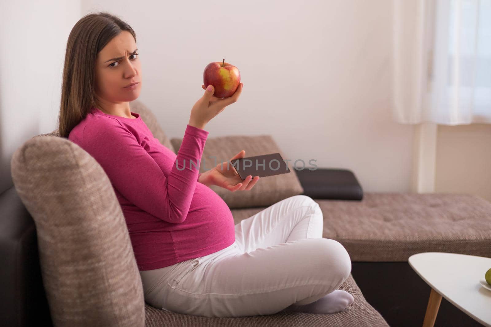 Angry pregnant woman doesn't want to eat fruit.
