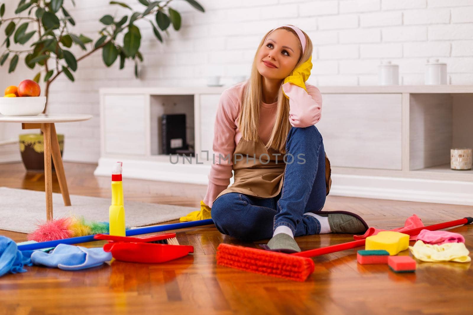 Beautiful housewife taking a break while cleaning her home.