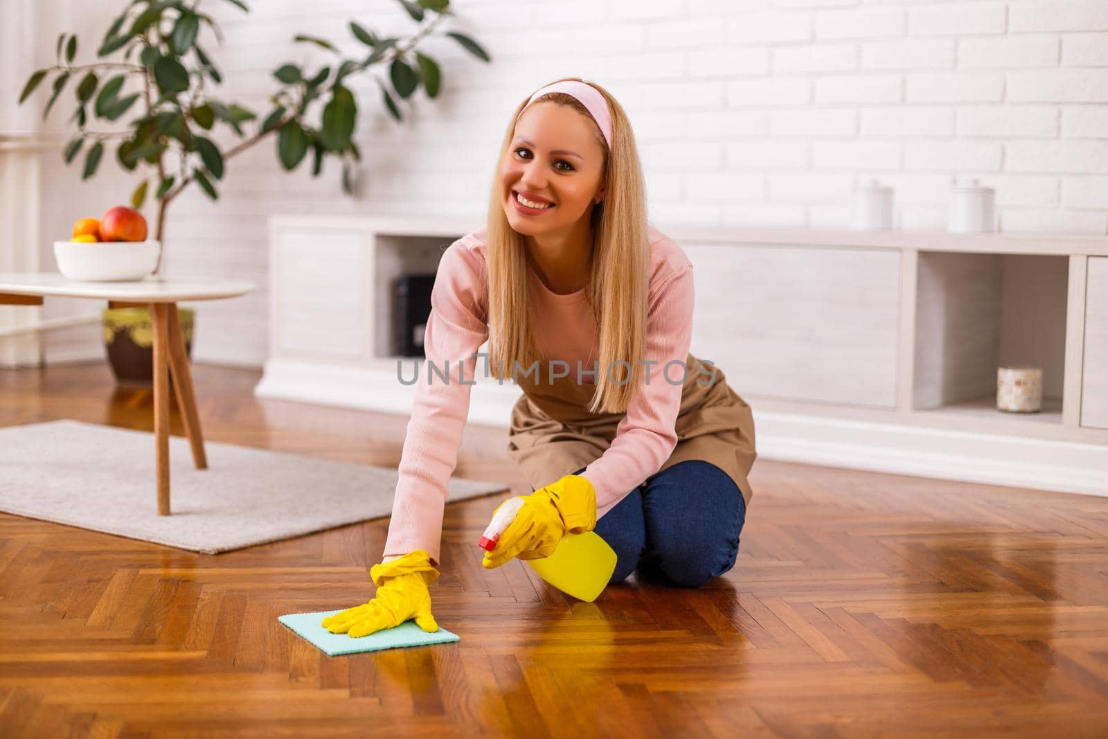 Beautiful housewife enjoys cleaning  her home.