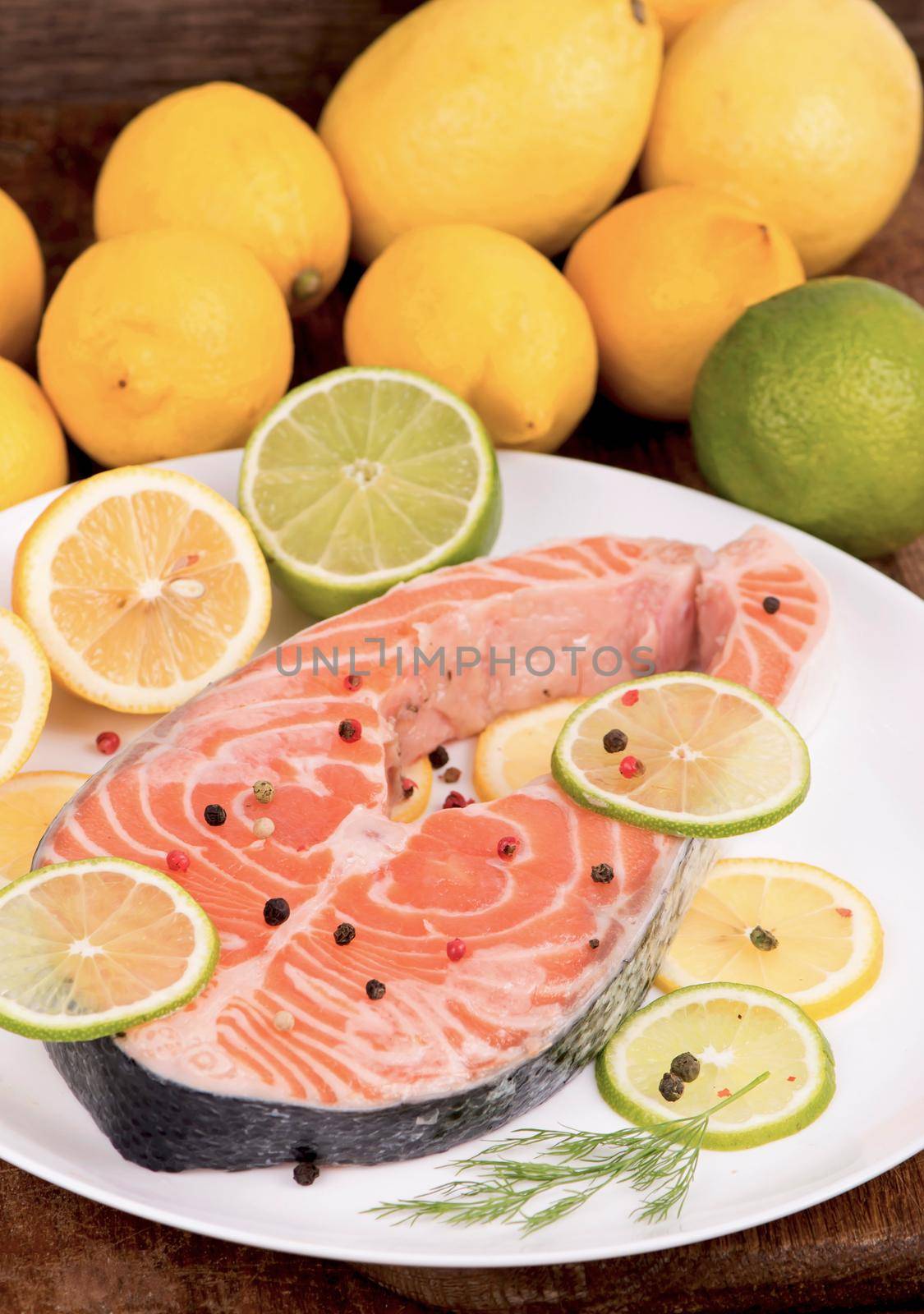 Steak of red fish and sliced lemons on white. by aprilphoto
