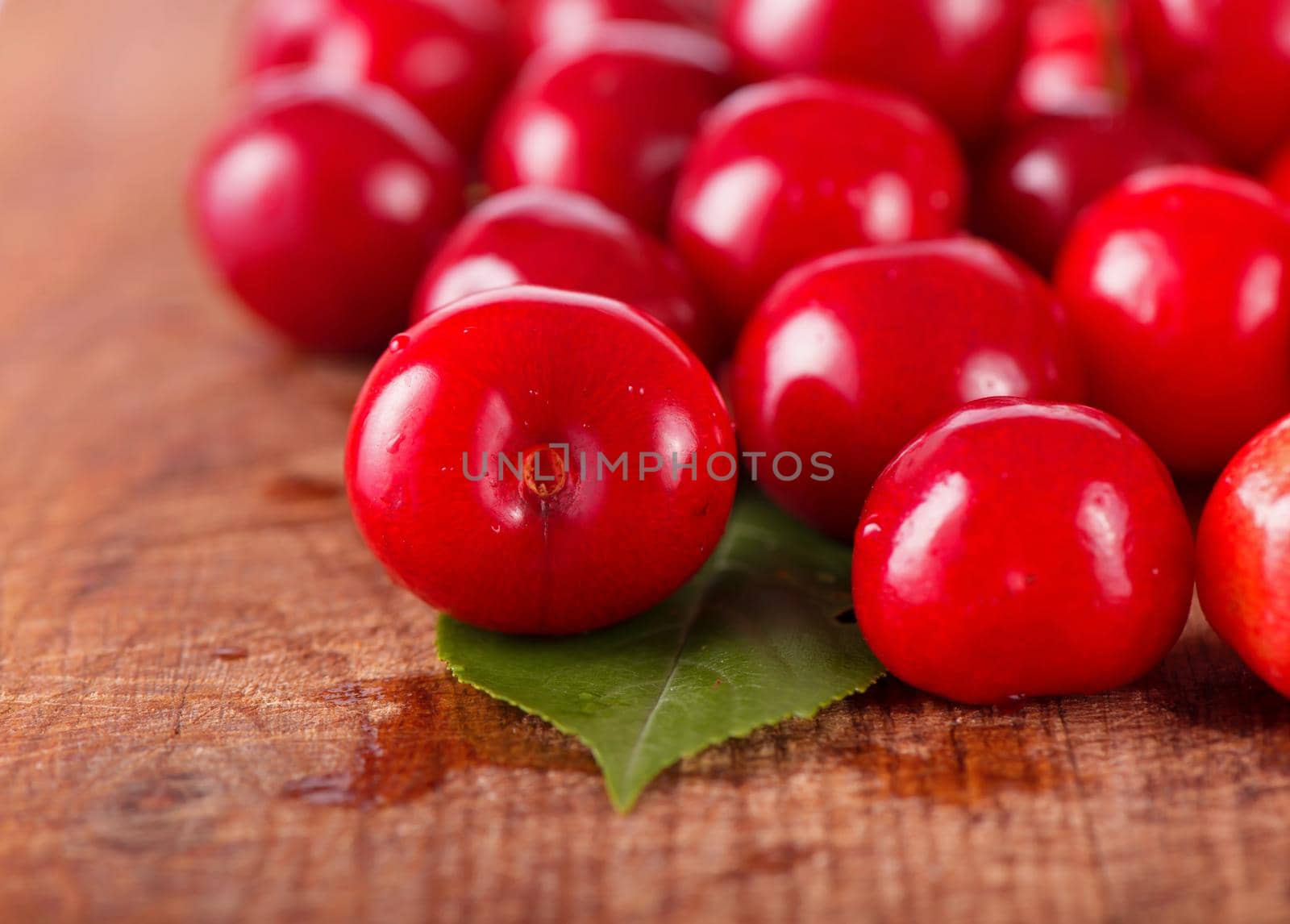 Cherries on wooden table with water drops by aprilphoto