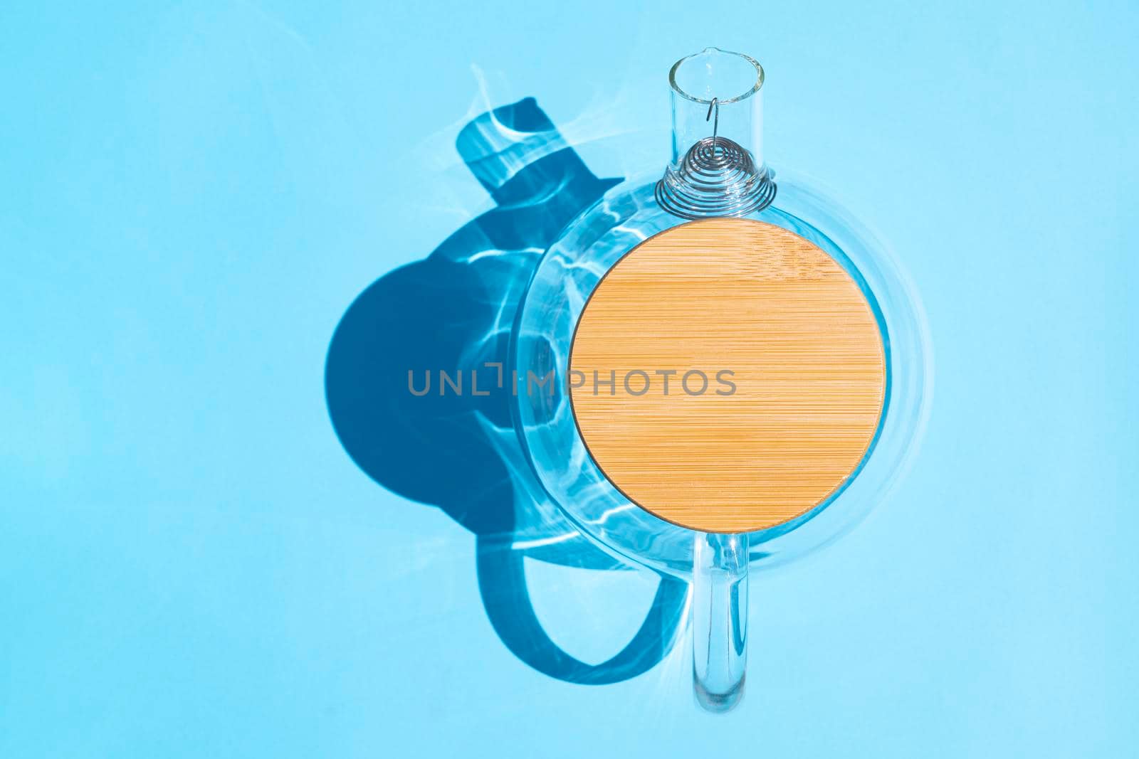 glass teapot with a hard shadow on a colored background. High quality photo