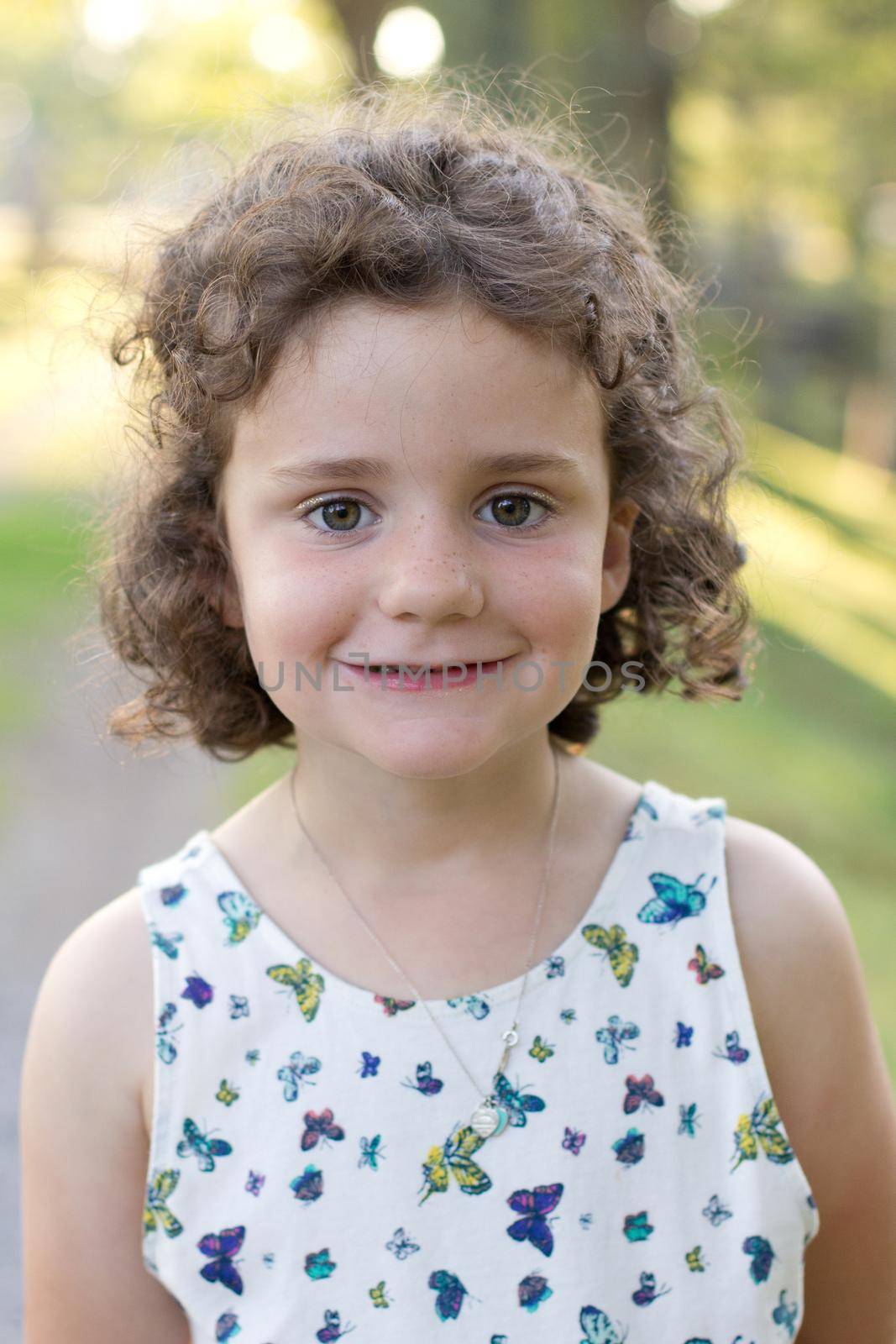 portrait of a young girl with curly hair in a butterfly dress