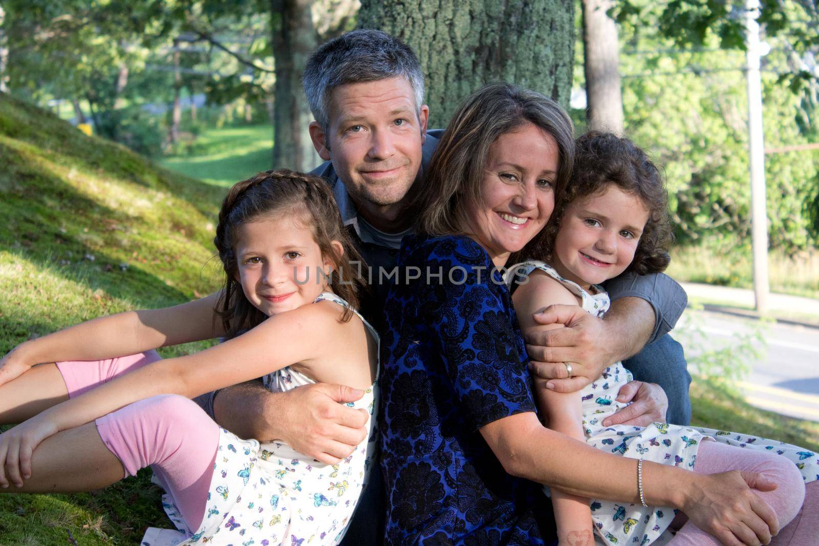 father, mother and their two beautiful daughters in a portrait outside