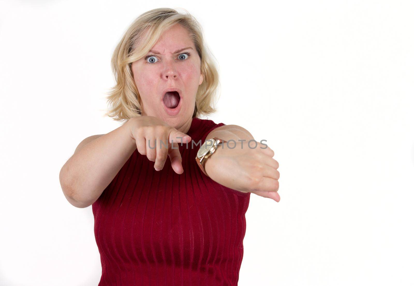 woman points at her watch with expression of shock or horror, realizing she is late