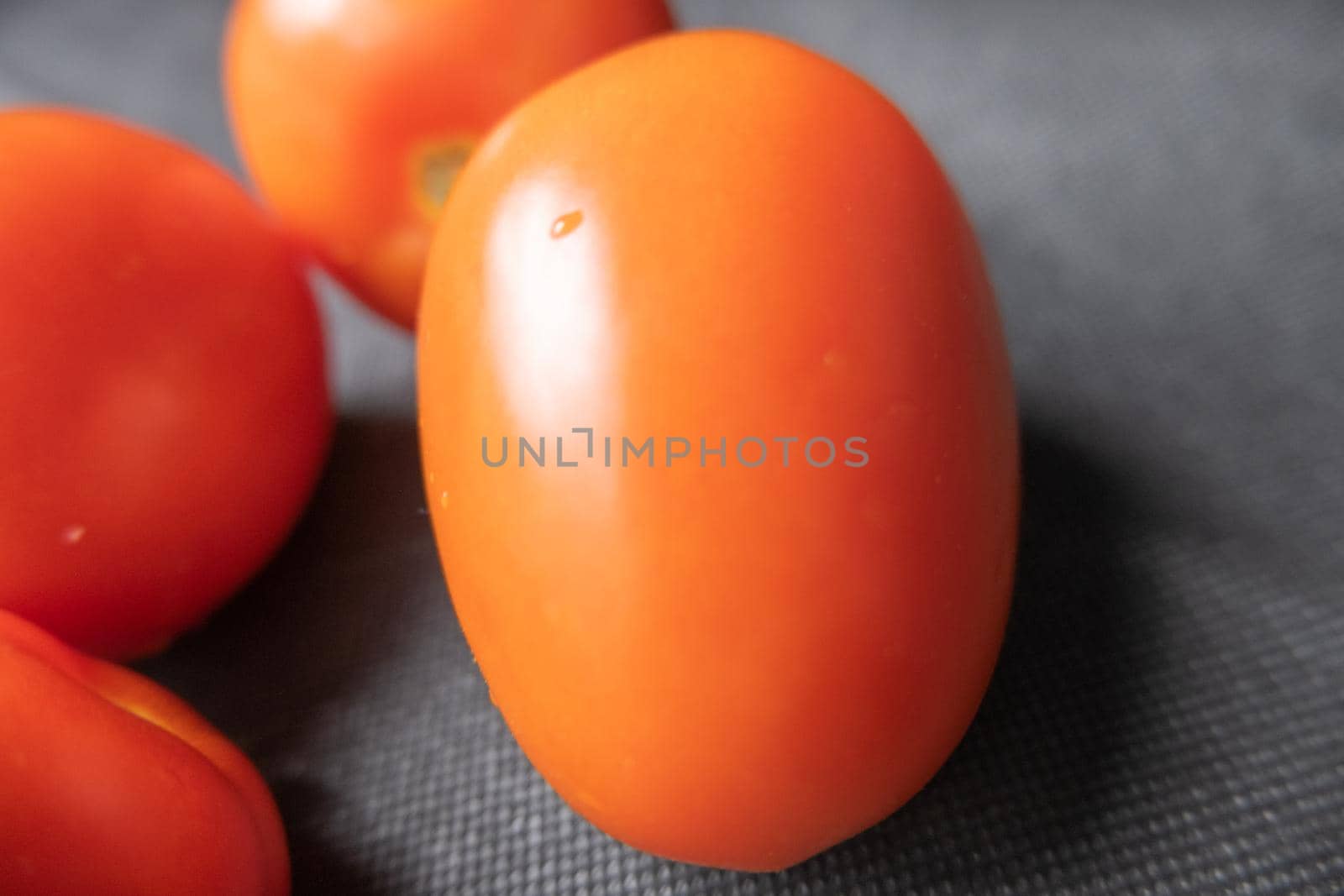 Close-up of fresh tomatoes on a dark blue table by Kanelbulle