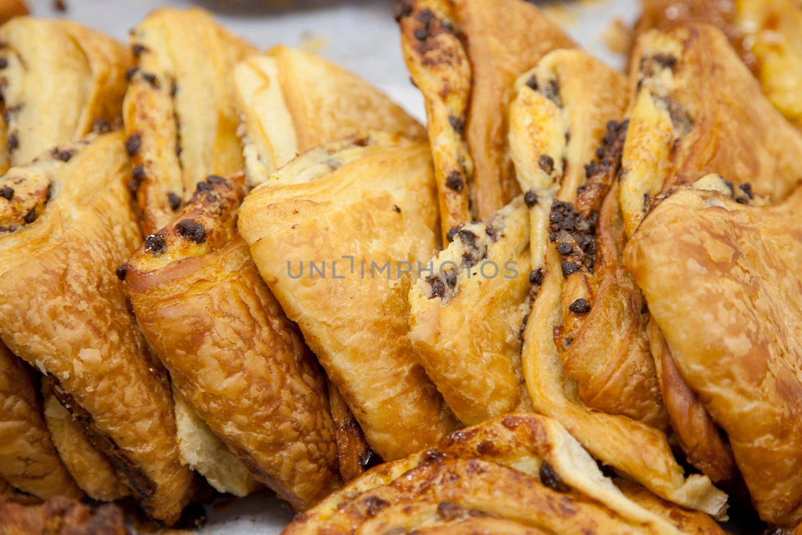 Delicious fresh pastry croissants with tiny chocolate chips at a market 