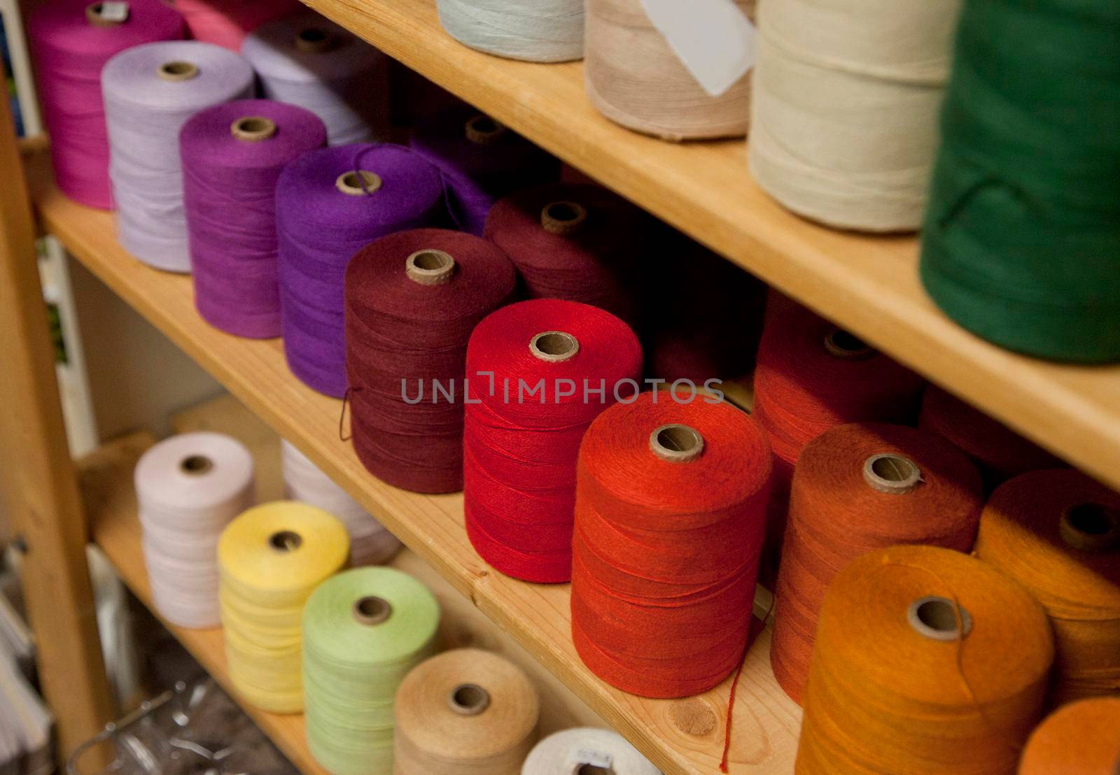 colorful bobbins or spools of purple, red, pink thread 