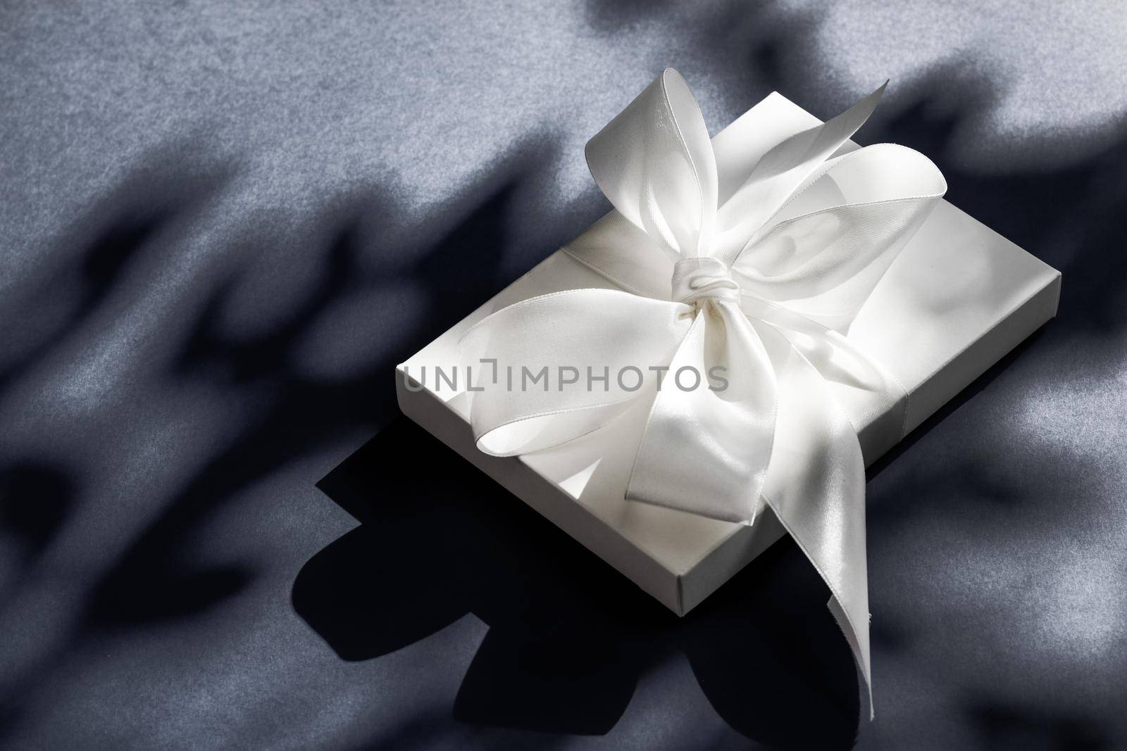 Anniversary celebration, shop sale promotion and luxe surprise concept - Luxury holiday white gift box with silk ribbon and bow on black background, luxe wedding or birthday present