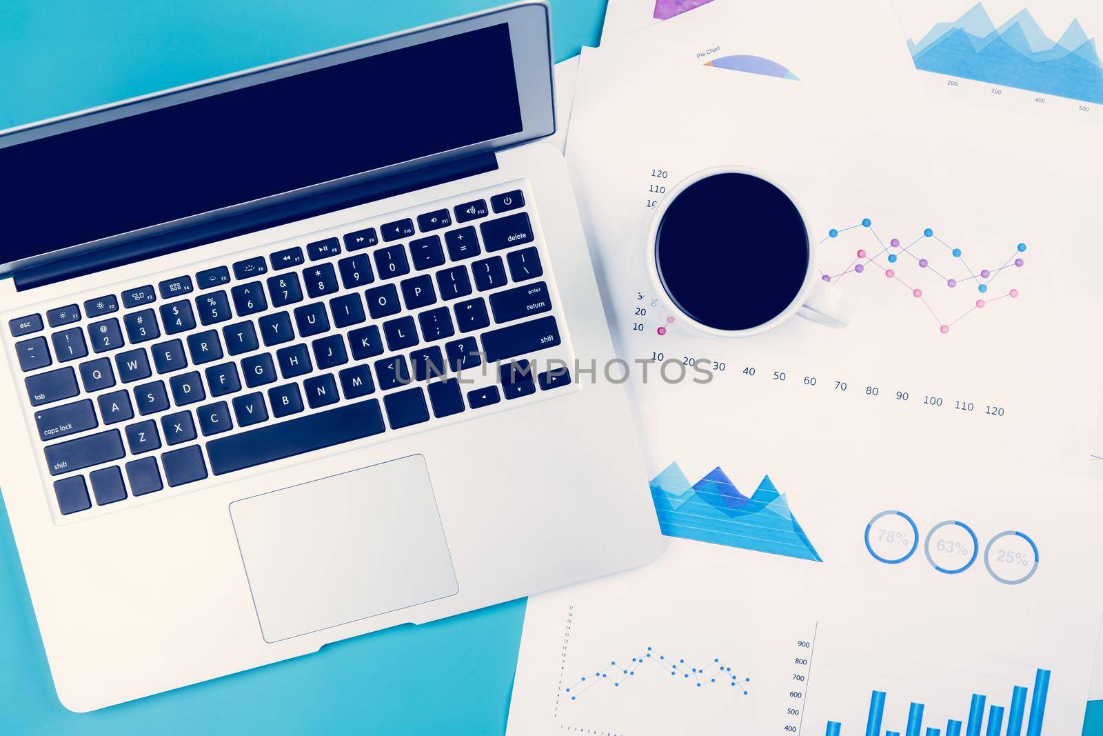 Laptop computer and documents report statistic financial with graph and chart and coffee on desk, finance and invest, digital marketing and growth of revenue, business and communication concept. by nnudoo