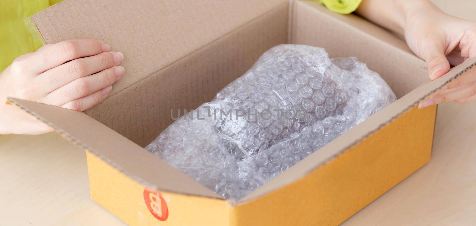 Closeup hand of woman opening parcel box with check product at home, female unpack with knife, delivery and shipping, shipment and express for shop, online shopping store and service concept. by nnudoo