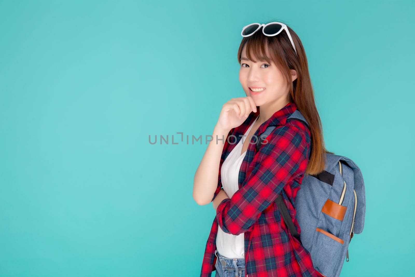 Beautiful portrait young asian woman wear sunglasses on head smile confident thinking and idea summer holiday isolated blue background, model girl fashion in vacation, travel concept.