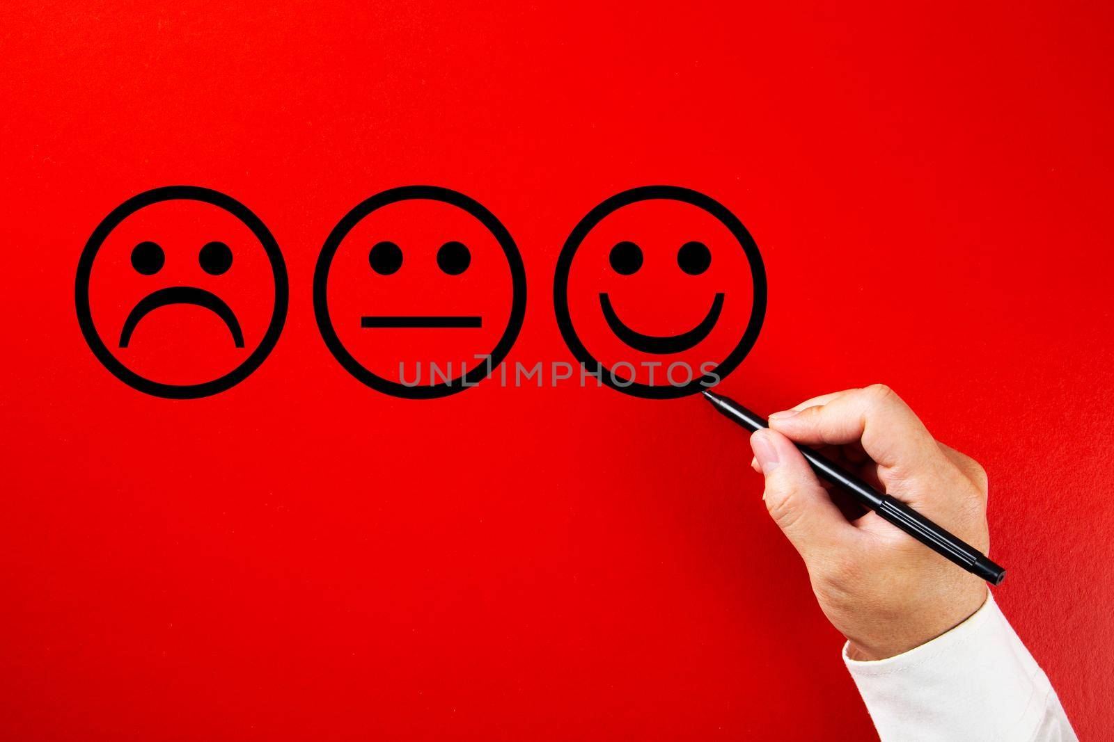 Businessman hand drawing a smiling happy face sketch on red background. Client satisfaction, service or product evaluation concept.