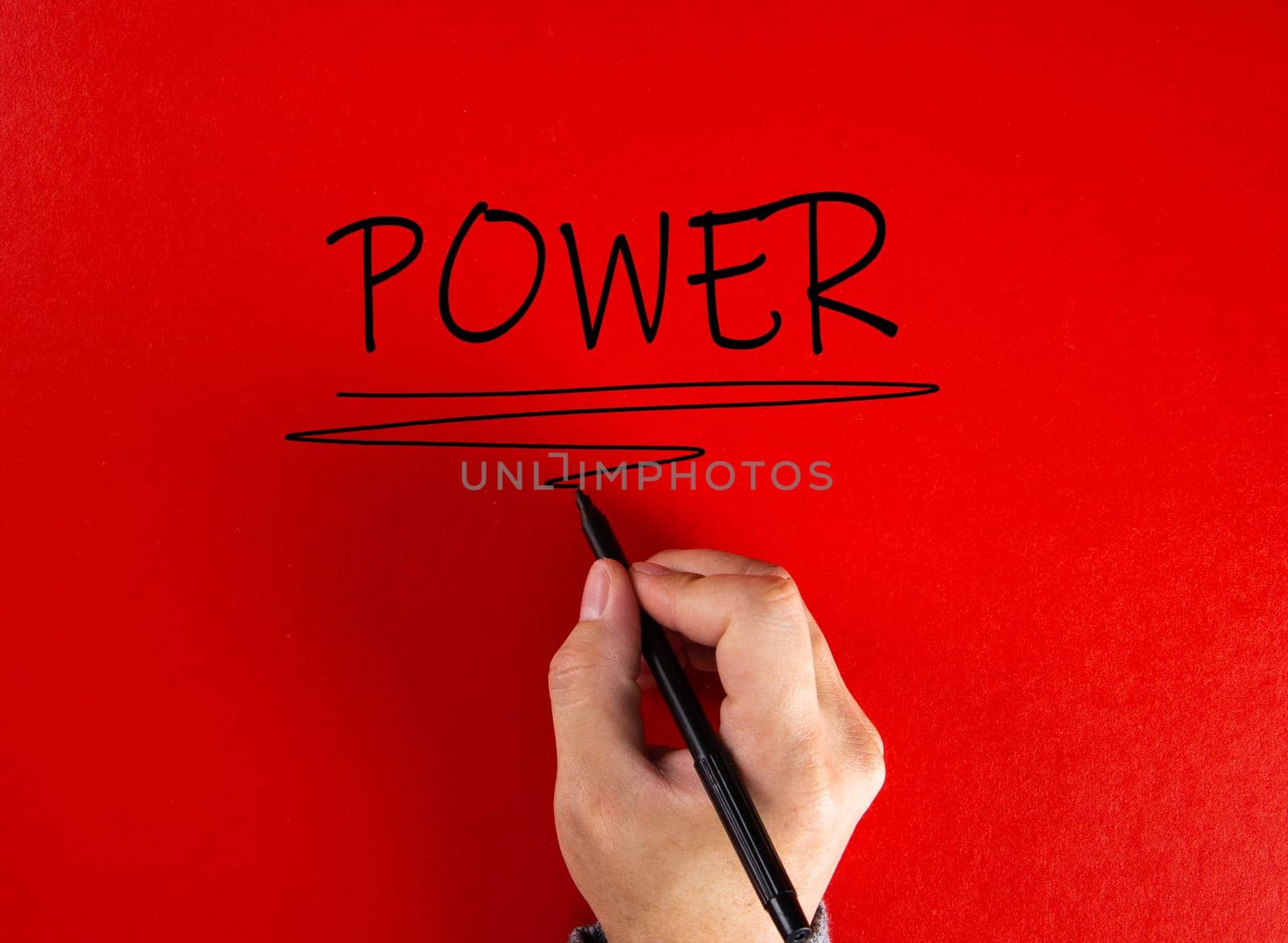 Male hand writing the word power on red background. Attaining power in business or life concept. by tehcheesiong