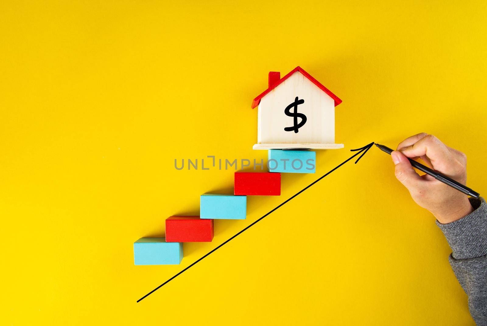 businessman drawing an arrow up above the houses. The concept of growth in demand for real estate and Increase in the value of property,