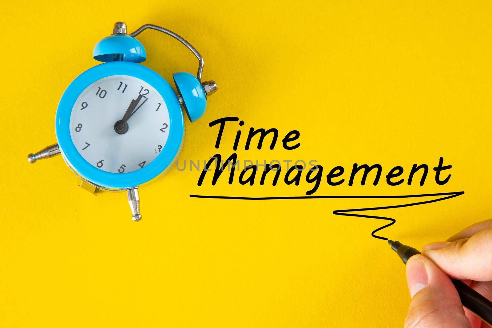 Hand writing Time Management with marker on yellow background, business concept