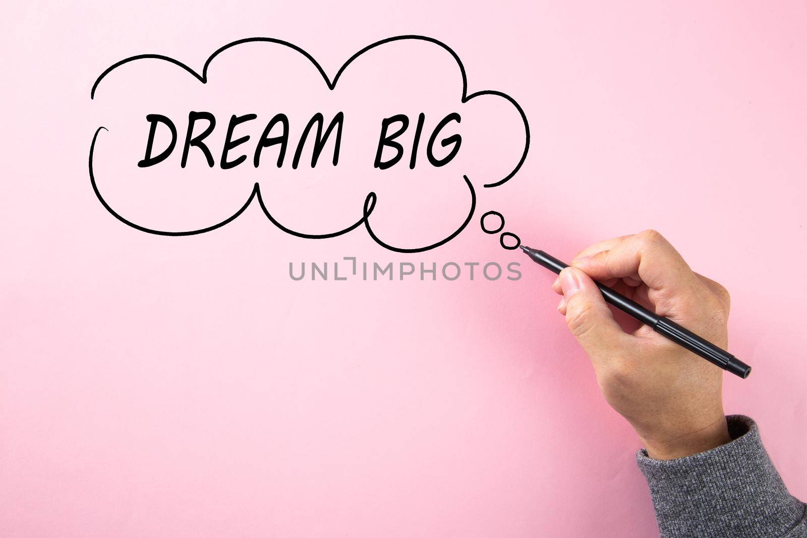 Hand writing Dream Big in cloud bubble on pink background