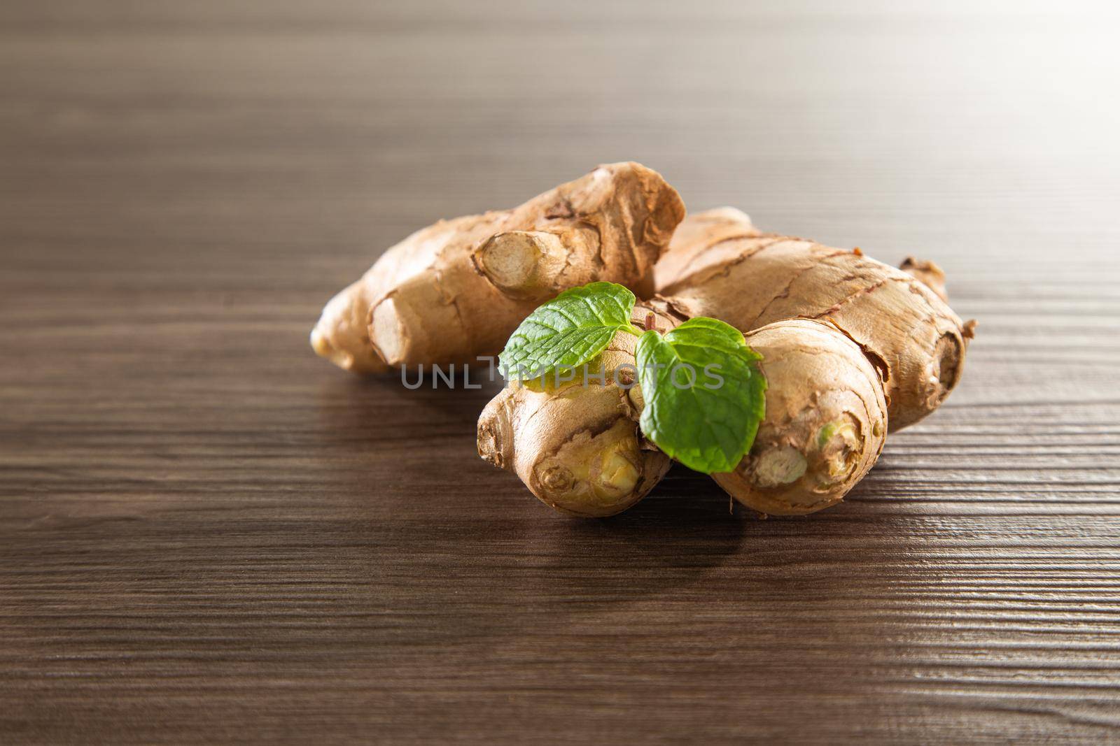Fresh ginger root on the wooden table by tehcheesiong