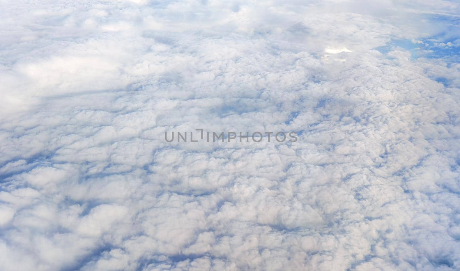 Fluffy clouds that looks as flat surface as seen from commercial airplane.