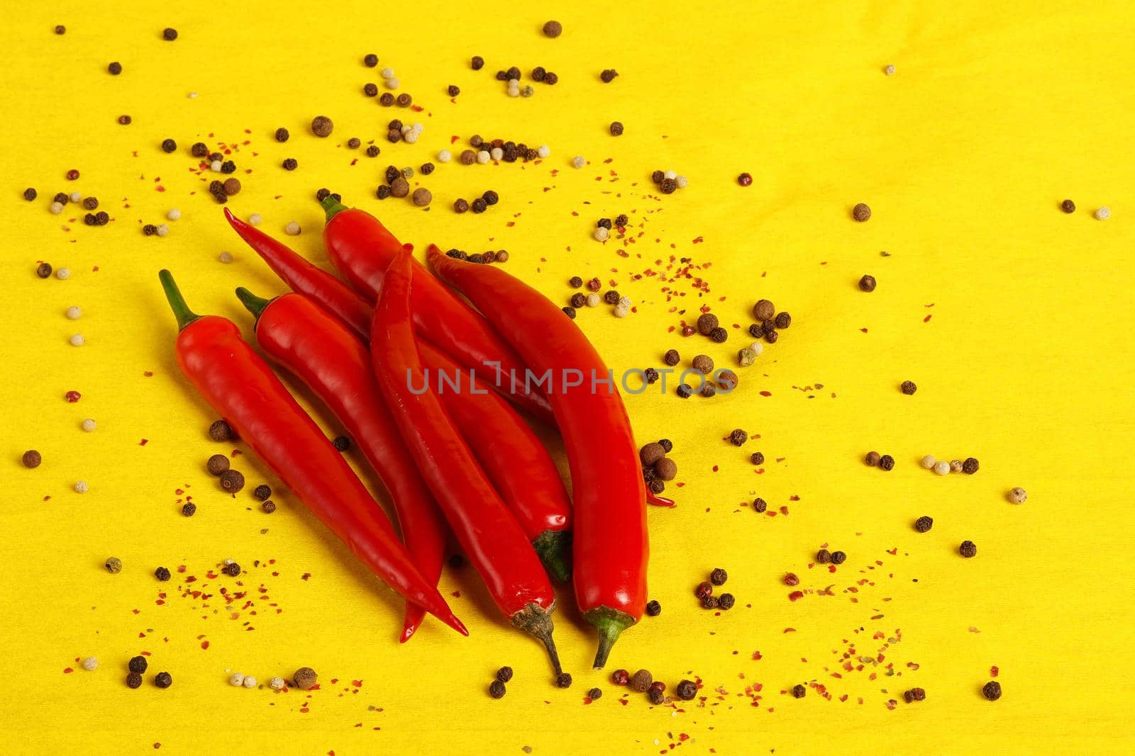 Red chili peppers on a yellow background, a place for inscription. by Olga26