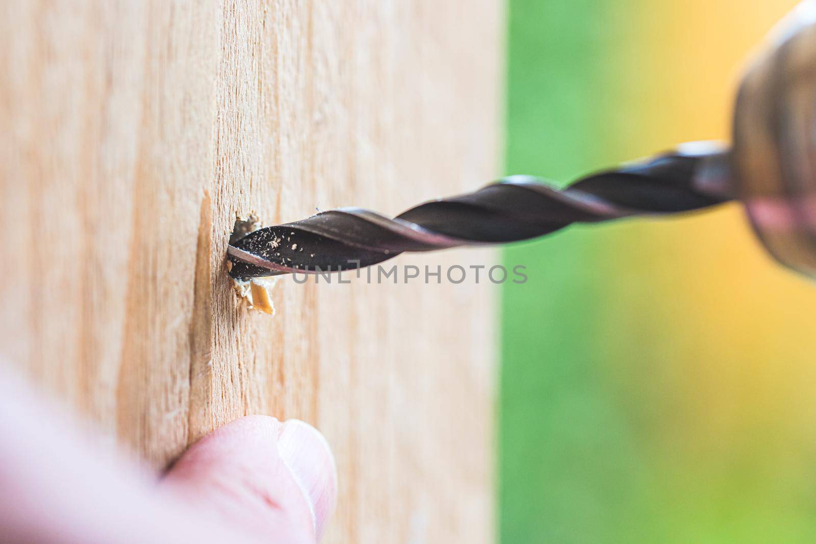 Do it yourself home handyman is using a drill for drilling wood