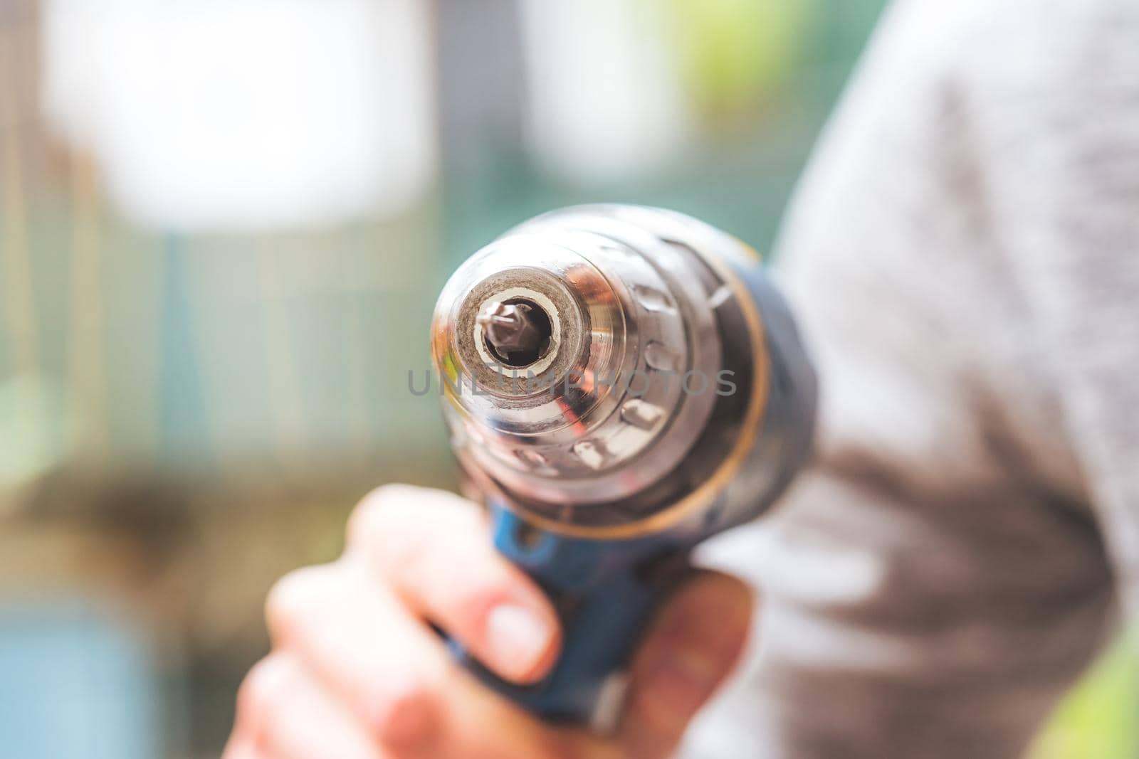Do it yourself home handyman is holding a cordless screwdriver, outdoors