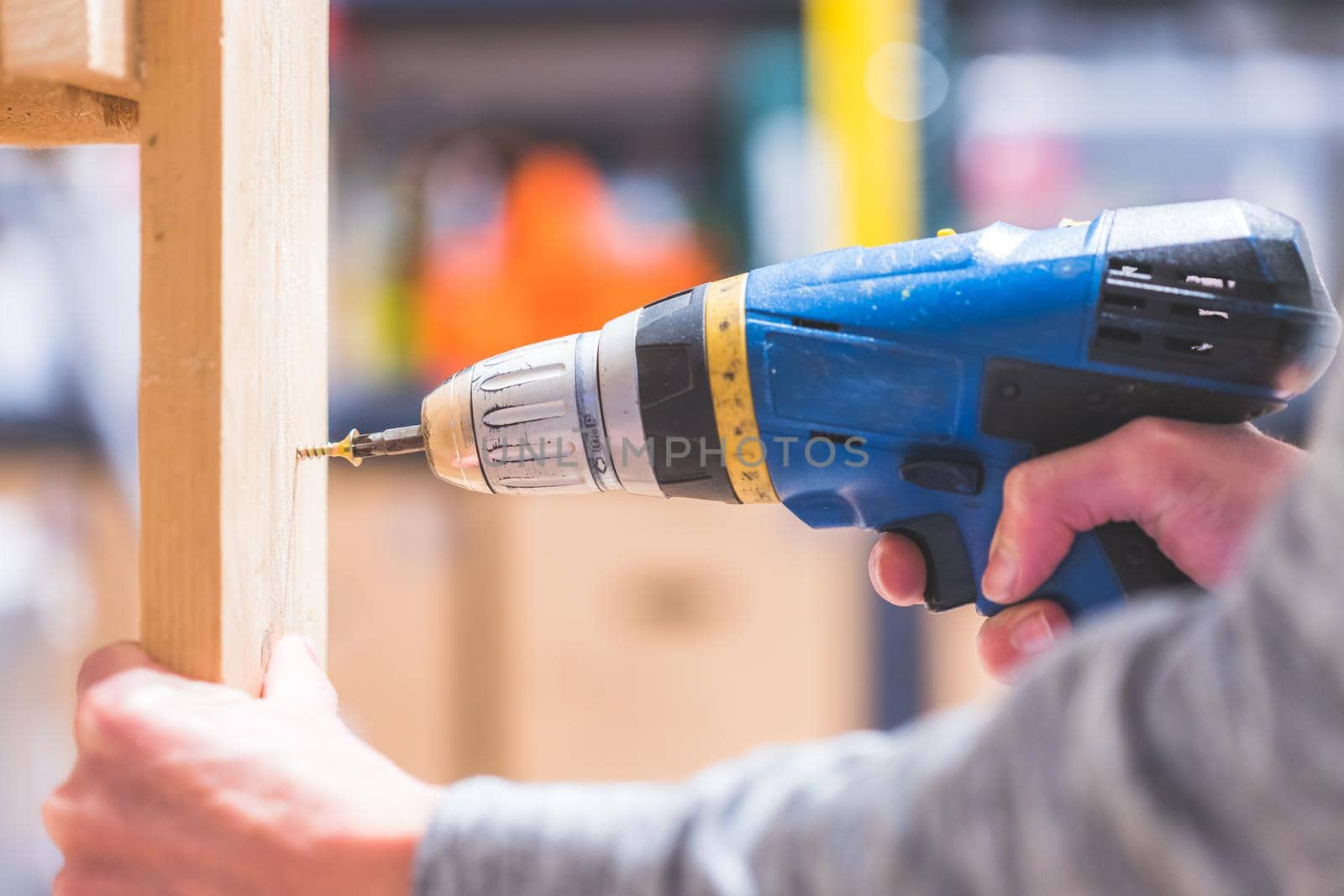 Do it yourself home handyman is using a cordless screwdriver for screwing