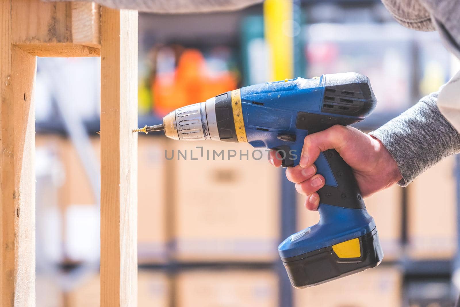 Do it yourself home handyman is using a cordless screwdriver for screwing