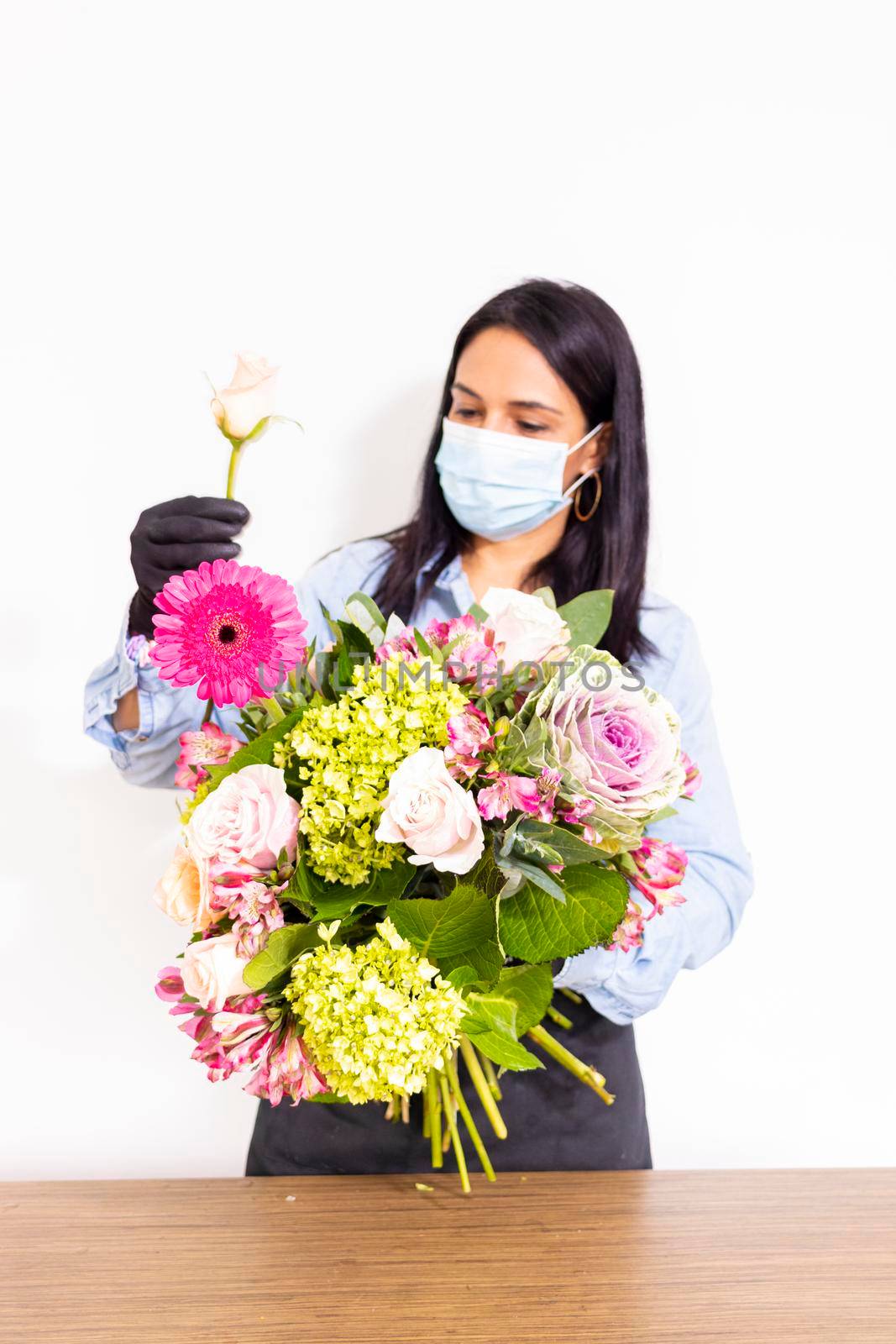 Cute woman florist is making a bouquet of roses, hydrangeas and alstroemerias by eagg13