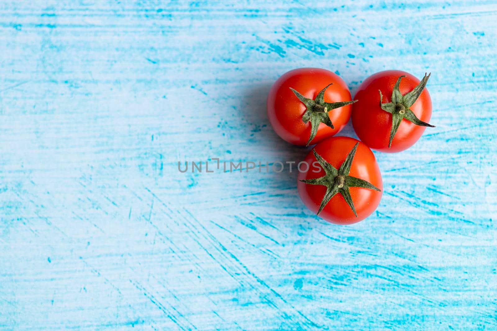 Cherry tomatoes on blue brushstroke background