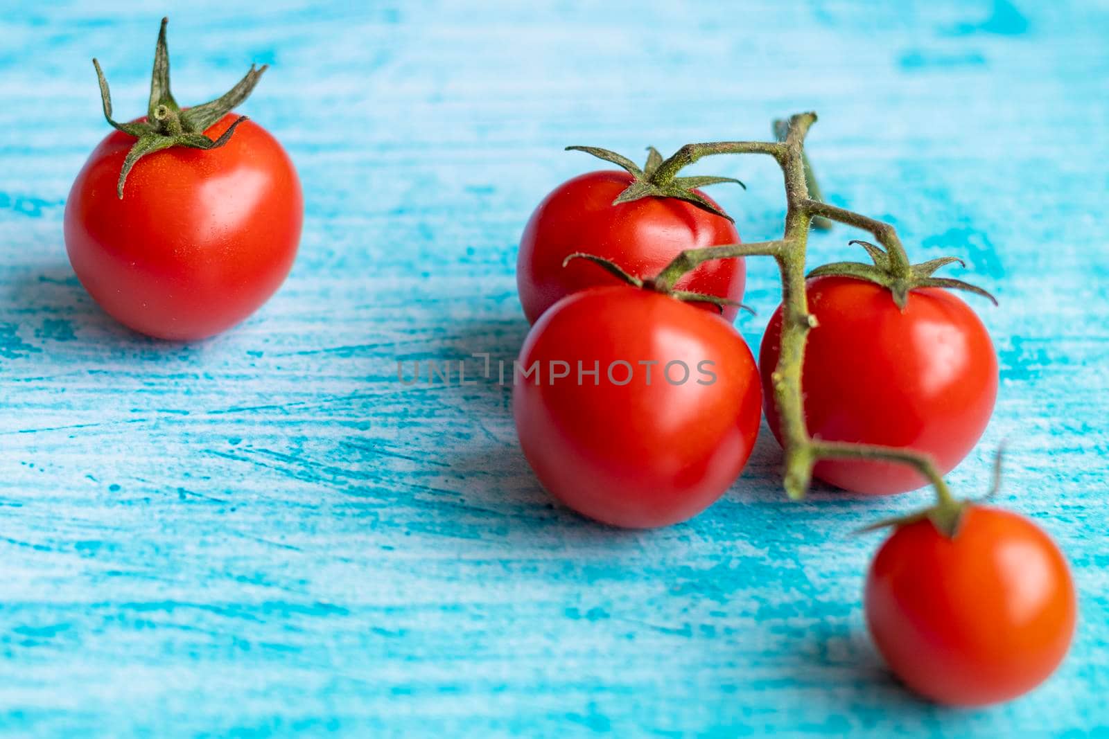 Cherry tomatoes on blue brushstroke background