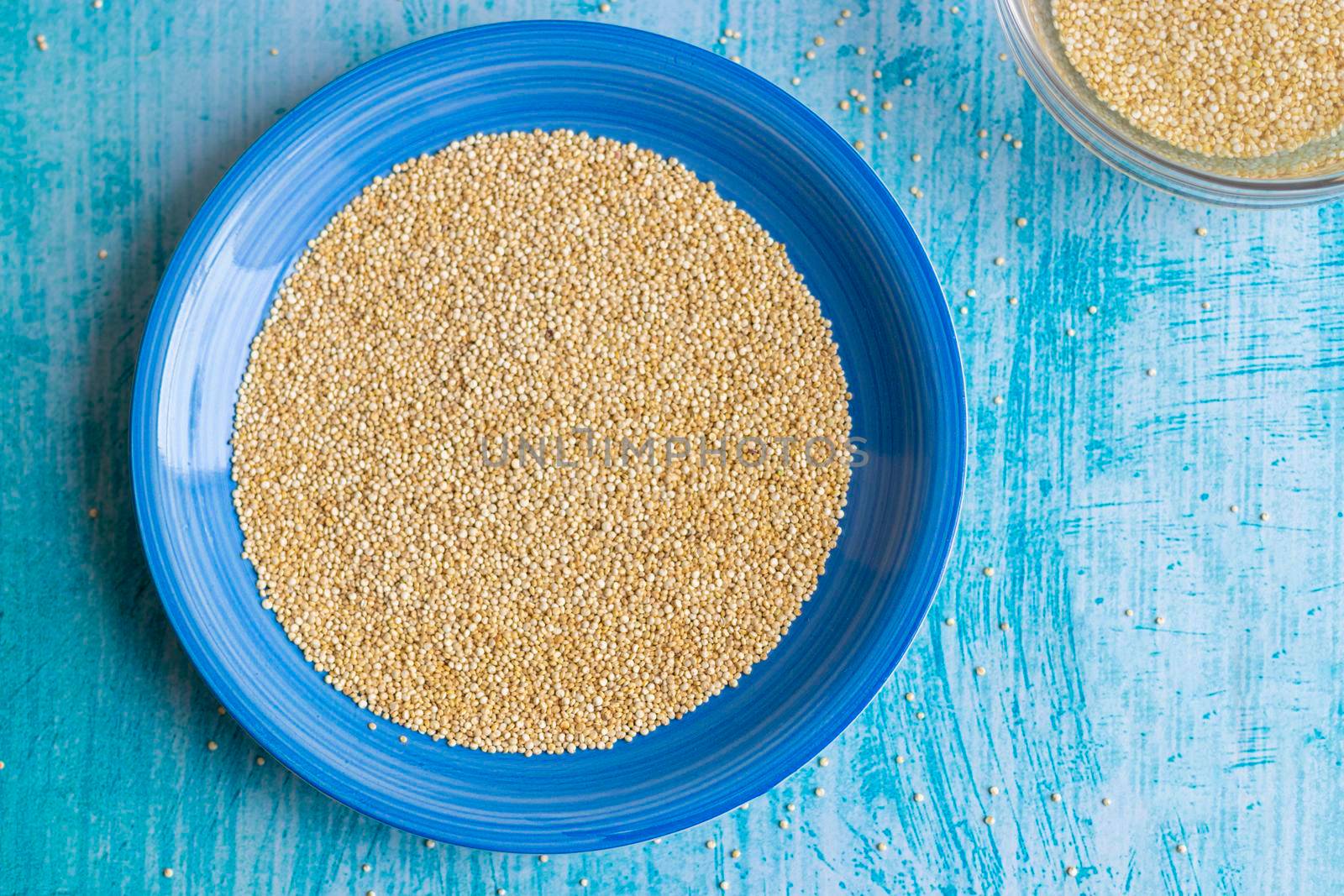 Uncooked quinoa grains inside blue plate by eagg13