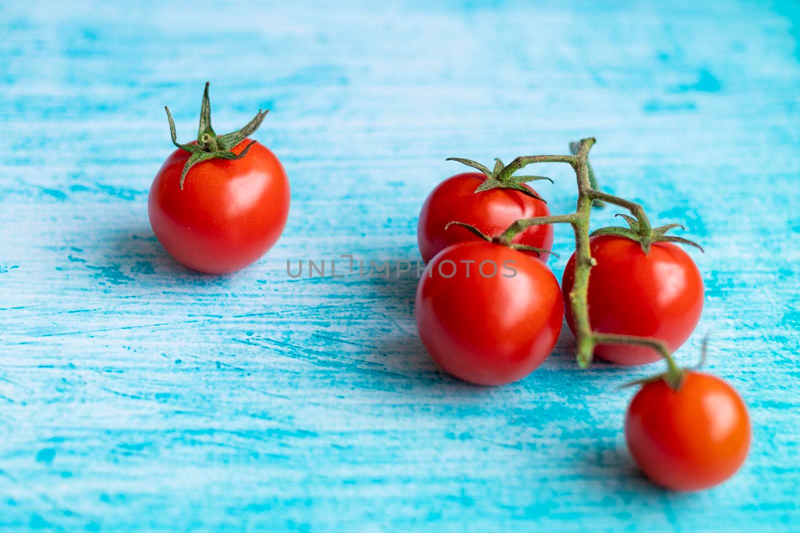 Cherry tomatoes on blue brushstroke background