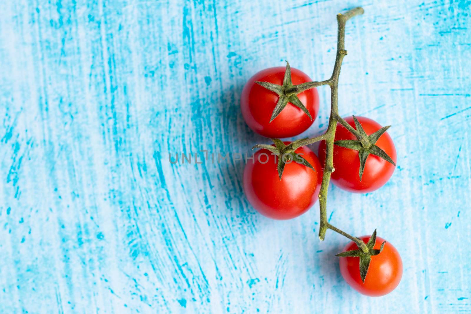 Cherry tomatoes on blue brushstroke background by eagg13